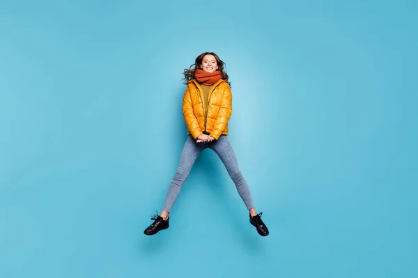 Full size photo of amazing cute model lady jumping high enjoy weekend relaxing walk street playful wear stylish windbreaker jeans scarf sweater isolated blue color background — Stock Fotó