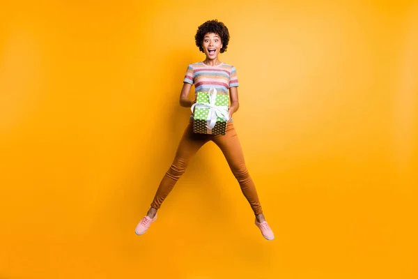Full length body size foto van vrolijke positieve schattig leuk fascinerend krullend golvend vriendin dragen gestreepte t-shirt oranje broek broek schoenen geïsoleerd over levendige gele kleur achtergrond — Stockfoto