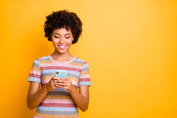 Zdjęcie wesoły uroczy uroczy pozytywna dziewczyna przeglądająca jej telefon w poszukiwaniu nowych informacji o blogowaniu izolowane na żywe żółte tło — Zdjęcie stockowe