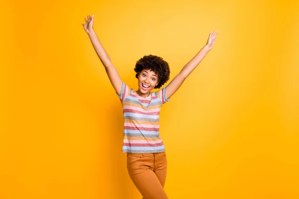 Foto de uma senhora de pele escura muito feliz com muito tempo esperou dia ensolarado de verão levantando os braços para cima indo para fora desgaste casual listrado t-shirt calças isoladas fundo amarelo — Fotografia de Stock