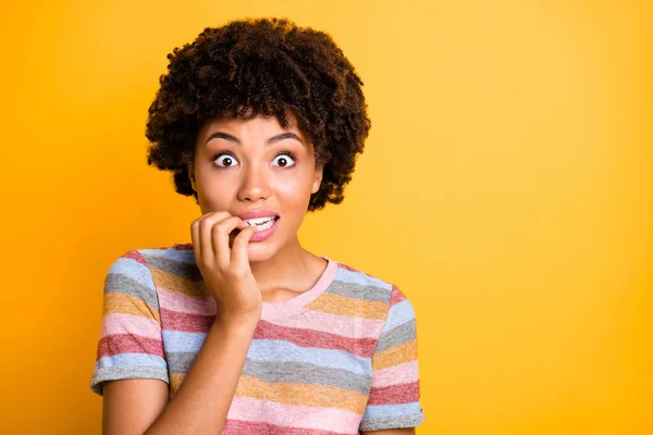 Foto de impactada novia negra impresionada mordiéndose las uñas mirando las ventas que no ha esperado ver cerca del espacio vacío aislado sobre un fondo de color amarillo vivo —  Fotos de Stock