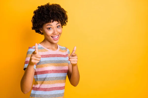 Photo of cheerful cute positive nice charming girlfriend proud of you wearing striped t-shirt smiling toothily pointing at you with forefingers isolated over yellow vivid color background — Stockfoto