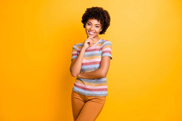 Foto de alegre linda chica encantadora positiva usando pantalones pantalones a rayas camiseta sonriendo toothily aislado sobre fondo de color amarillo vivo en un ajuste de lluvia de ideas — Foto de Stock