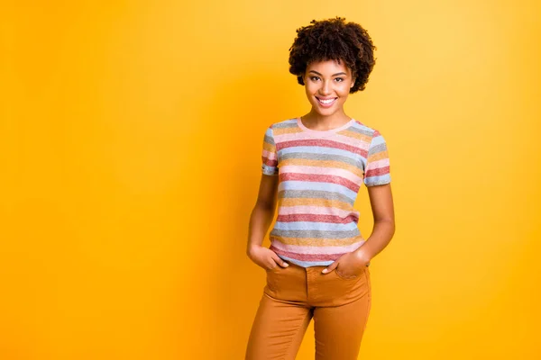 Photo of wavy cheerful cute nice charming girlfriend standing confidently with hands in trousers pockets isolated over vivid color background — Stock Photo, Image