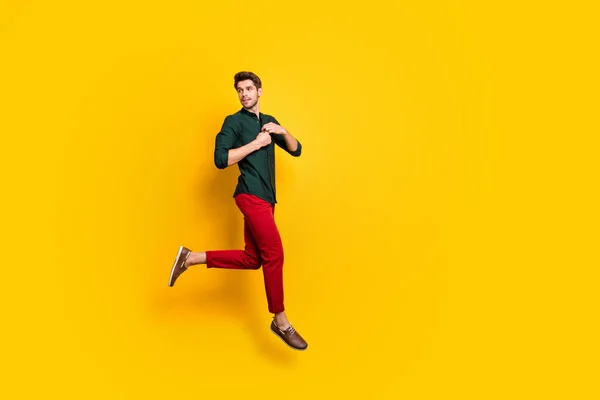 Full body profiel zijkant foto van prachtige chique elegante man voelen dromerige emoties sprong run op voorjaarsvakantie dragen casual stijl kleding sneakers geïsoleerd over gele kleur achtergrond — Stockfoto