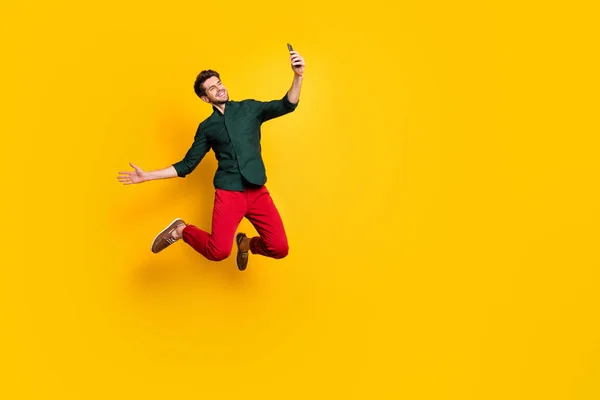 Foto von positiven fröhlichen Kerl auf Frühling Reise Urlaub springen Selfie Blogging Gruß tragen lässigen Stil Outfit Turnschuhe isoliert über gelben Farbhintergrund — Stockfoto