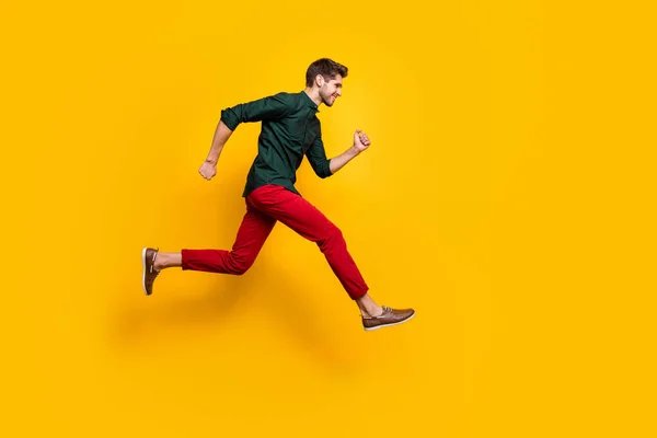 Full size profil stronie zdjęcie pozytywne wesoły facet skok bieg szybko chcesz spieszyć się do rabatów sprzedaży nosić casual styl ubrania trampki izolowane na żółtym tle kolor — Zdjęcie stockowe