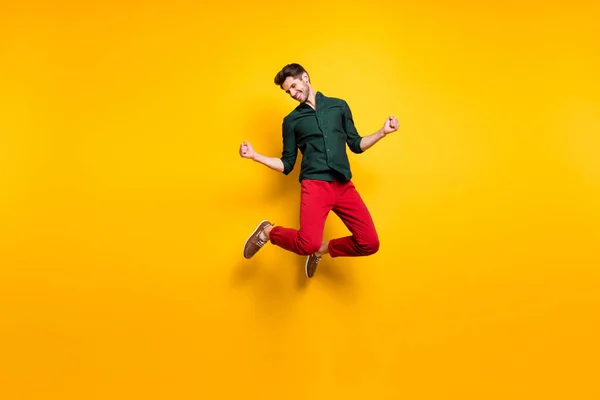 Retrato de funky loco extático chico salto sentirse afortunado celebrar su victoria en la competencia levantar los puños grito sí usar ropa casual estilo zapatillas aisladas sobre fondo de color amarillo —  Fotos de Stock