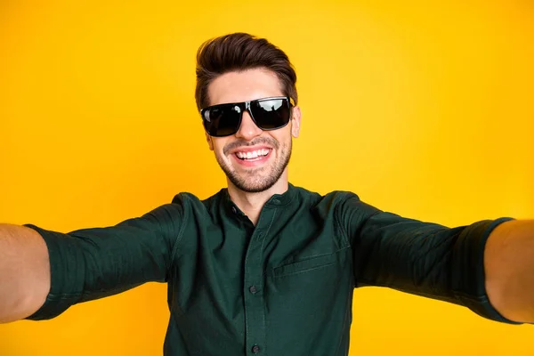 Photo of beaming toothy attractive cool man taking selfie holding camera with both hands smiling with bristle on face in summer isolated vivid color background — Stock Photo, Image