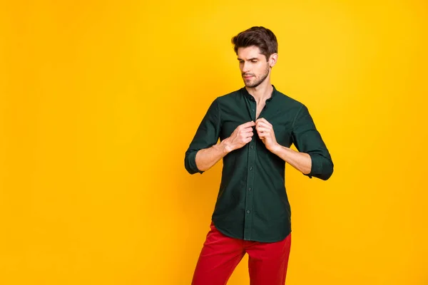 Foto de hombre de negocios confiado ajustando sus botones en la camisa mirando hacia abajo pensativamente en pantalones aislados color vivo fondo — Foto de Stock