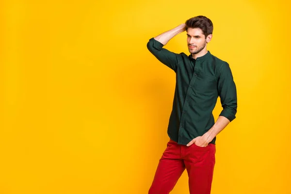 Photo de sérieux attrayant homme impressionnant portant un pantalon rouge peigner ses cheveux avec soies isolées sur fond jaune vif — Photo