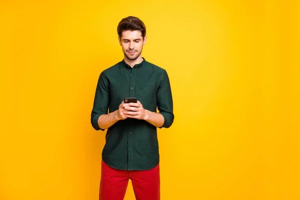 Photo d'un bel homme sérieux confiant tenant le téléphone avec les mains avec la soie près de l'espace vide isolé fond de couleur vibrante — Photo