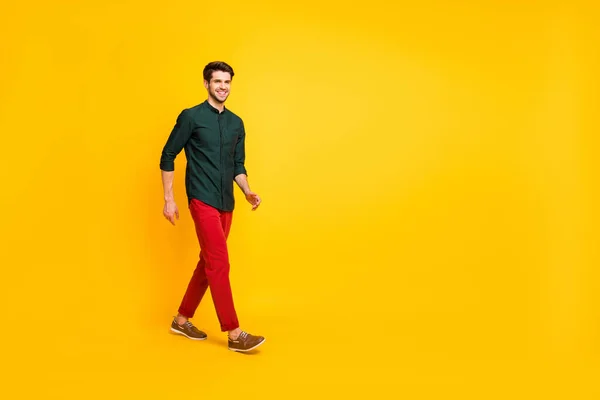 Полная длина фото позитивного веселого парня есть свободное время идти ходить носить повседневную одежду кроссовки изолированы на желтый цвет фона — стоковое фото