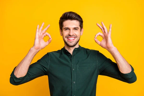Фото веселого доброго гарного чоловіка, який показує вам подвійний знак ОК, посміхаючись зубно з щетиною, ізольовані на жовтому яскравому кольоровому фоні — стокове фото