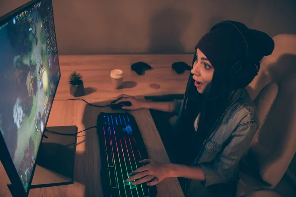 Boven hoge hoek uitzicht foto van vrolijk positief mooi lief meisje in cap hoofddeksel drukken toetsenbord met lang brunette haar spelen video game 's nachts — Stockfoto