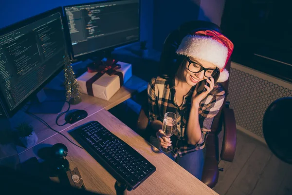 Hochwinkel Ansicht Foto von workaholic Dame Programmierung Entwickler Arbeit Neujahr Nacht Büro sprechen Telefon Verwandte trinken Sekt tragen Weihnachtsmütze Gläser drinnen — Stockfoto