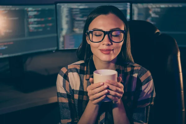 Foto gadis ceria yang puas dalam kacamata menikmati aroma kopi yang baru diseduh dengan latar belakang monitor java script — Stok Foto