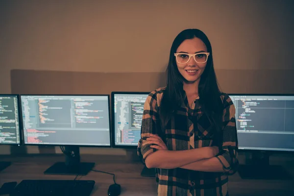 Foto de alegre alegre positivo alegre sorridente menina sorrindo radiante em pé no fundo de várias telas com códigos de script — Fotografia de Stock