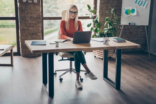 Foto de cuerpo completo de la exitosa mujer encantadora empresa propietaria sentarse mesa trabajo portátil hacer proyecto de inicio usar cuello alto rojo en el lugar de trabajo loft oficina —  Fotos de Stock