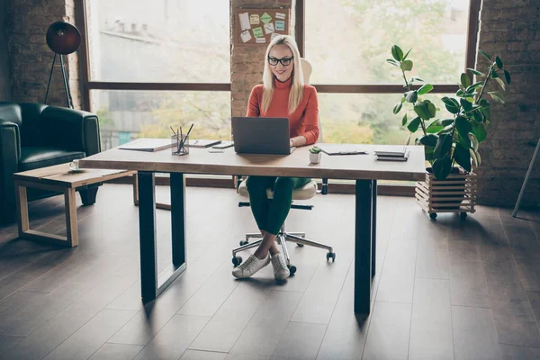Foto em tamanho completo de mulher positiva trabalhador sentar mesa uso laptop trabalho no start-up estratégia tipo desgaste gola alta vermelha no sótão do escritório — Fotografia de Stock