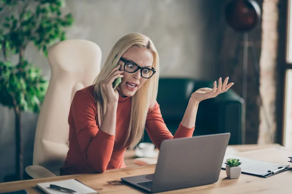 Mulher indignada gerente executivo sentar mesa uso laptop ler start-up projeto encontrar erro sentir raiva chamada empregado smartphone tem argumento gritar escritório loft estação de trabalho vermelho gola alta — Fotografia de Stock