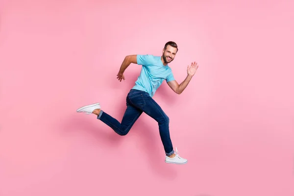 Profil latéral pleine longueur taille du corps photo de joyeux homme sautant positif en cours d'exécution aspirant à venir pour les ventes dans le temps isolé rose fond de couleur pastel — Photo