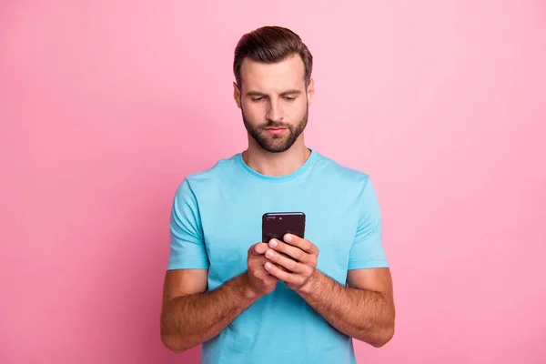 Photo d'homme pensif réfléchissant réfléchissant naviguant à travers le téléphone en regardant dans l'écran isolé fond de couleur pastel — Photo