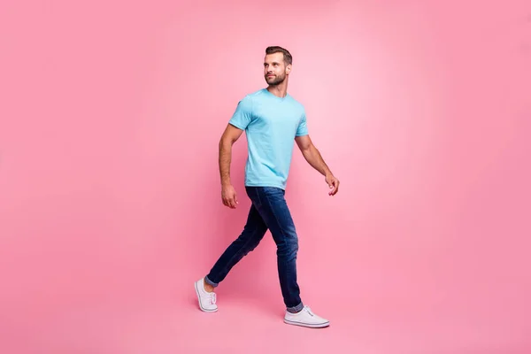 Zdjęcie odwrócił człowieka w dżinsach dżinsy spaceru do przodu patrząc wstecz w tenisówki izolowane pastelowe tło kolor — Zdjęcie stockowe