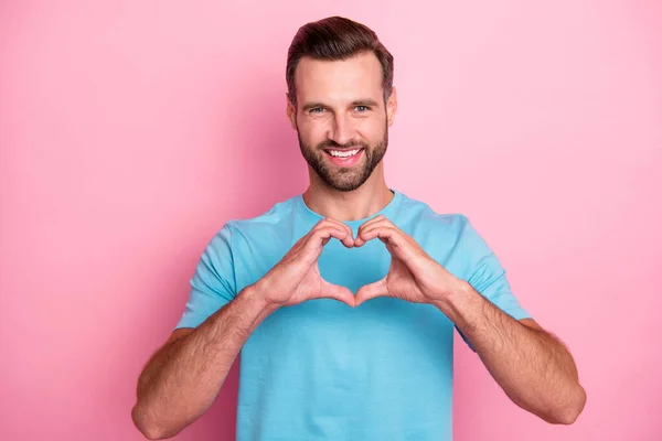 Foto de alegre hombre atractivo positivo que muestra el signo del corazón en forma de dedos para mostrar su amor a usted fondo de color pastel aislado — Foto de Stock