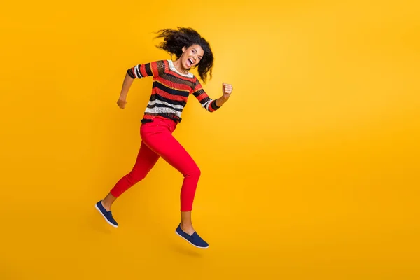 Volledige lengte profiel zijkant foto van gekke funky meisje springen run haast na de herfst vallen zwarte vrijdag koopjes voelen opgewonden schreeuw dragen rode broek geïsoleerd over gele kleur achtergrond — Stockfoto