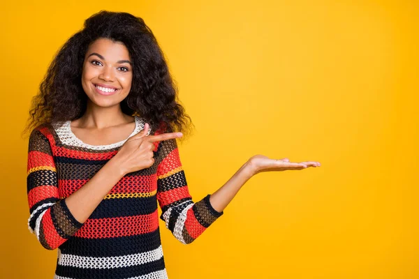 Close-up portrait of her she nice attractive cheerful cheery wavy-haired girl in knitted sweater demonstrating invisible object ad isolated on bright vivid shine vibrant yellow color background — Stock Photo, Image