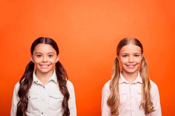 Hafta sonları yan yana eğlenen iki küçük çocuğun portresi. İçtenlikle gülümse. Portakal rengi arka planda izole edilmiş günlük kıyafetler giy. — Stok fotoğraf