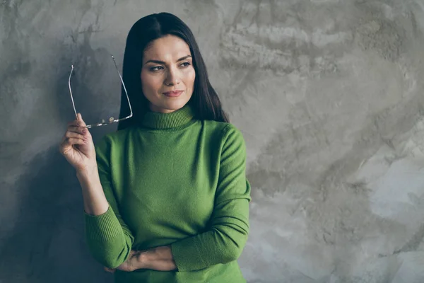 Foto av drömmande intresserad seriös kvinna som har tagit glasögon av tittar in i tomma rymden planering välja isolerad grå betong vägg bakgrund — Stockfoto