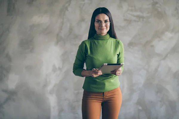 Foto av glada positiva söta söt kvinna håller gadget av hennes företag notera viktig information när du lyssnar på dig i orange byxor isolerad grå färg vägg betong bakgrund — Stockfoto