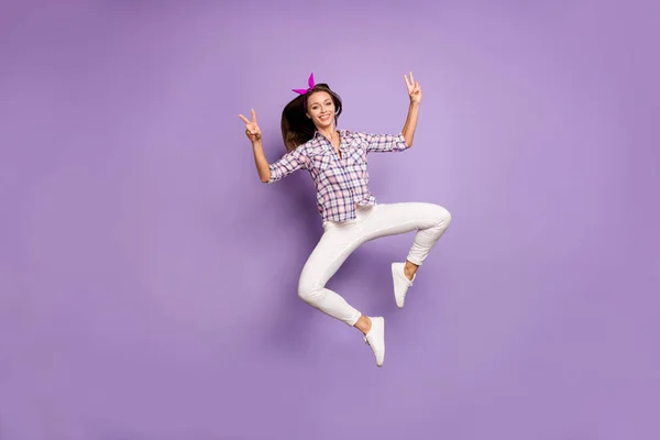 Full body foto di contenuto ragazza giovane godere di primavera fine settimana salto fare v-segni indossare casual stile abbigliamento scarpe da ginnastica isolato su sfondo di colore viola — Foto Stock
