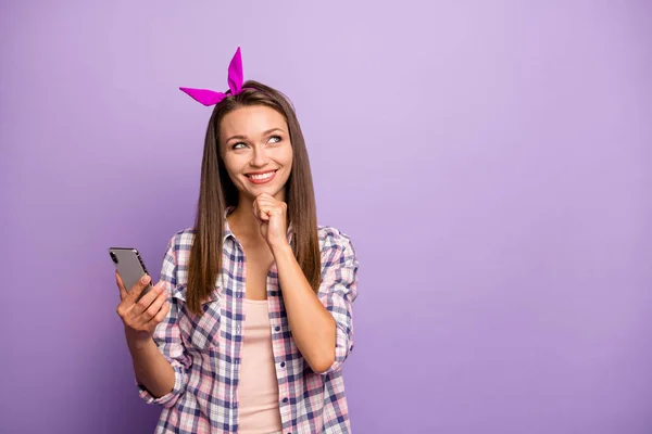 Портрет позитивної надихаючої дівчини використовує її смартфон думки вирішують вибрати те, що пост одягати картату ретро-сорочку ізольовано на фіолетовому кольоровому фоні — стокове фото
