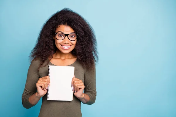 Porträt von flippigen lustigen afroamerikanischen College-Studenten halten Werbebuch fühlen sich positiv fröhlich tragen Stil grün Pullover isoliert über blauem Hintergrund — Stockfoto
