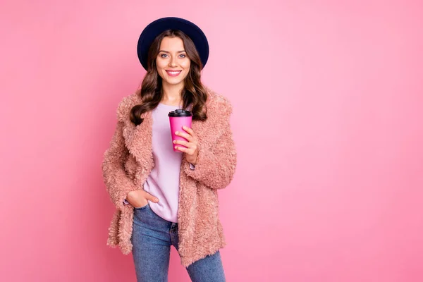 Foto di bella signora millenaria in possesso di carta da asporto tazza di caffè incredibile street look usura elegante inverno soffice giacca retro cappello jeans isolato rosa sfondo — Foto Stock