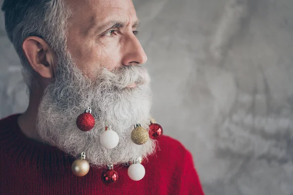 Beskuren profil sida foto av maskulin brutal gammal man ser elegant förbereda sig för jul tid fest hänga x-mas grannlåt skägg bära modern tröja isolerad över grå färg bakgrund — Stockfoto