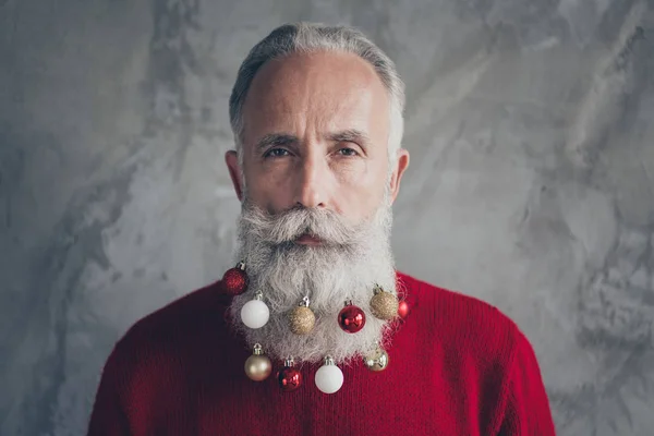 Çekici, yaşlı Noel Baba 'nın yakın plan fotoğrafı uzun sakallı, renkli oyuncak topları. Gülümsemeyen Noel Baba süslemeleri. Kırmızı kazak, hipster kıyafeti, izole edilmiş gri duvar arka planı. — Stok fotoğraf