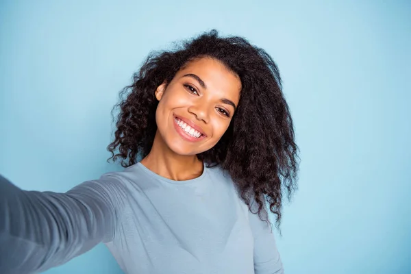 Selbstporträt von fröhlich lockig gewellte positive nette hübsche Freundin lächelt zahnhaft tragen blauen Pullover Selfie isoliert pastellfarbenen Hintergrund — Stockfoto