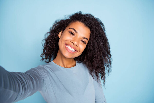 Self portrait of cheerful curly wavy positive nice cute pretty girlfriend smiling toothily wearing blue sweater taking selfie isolated pastel color background Royalty Free Stock Images