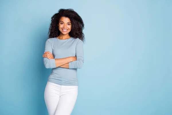 Foto de moda alegre lindo lindo bonito toothy radiante chica con las manos dobladas en pantalones blancos cerca de espacio vacío aislado pastel color azul fondo — Foto de Stock