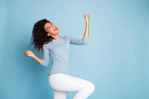 Turned photo of cheerful crazy excited overjoyed carefree girl screaming making fists in white pants rejoicing in victorious events isolated pastel blue color background — Stock Photo, Image