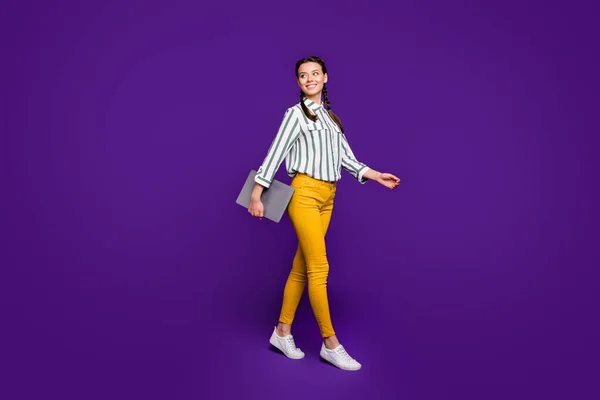 Foto de cuerpo completo de una mujer de negocios bonita freelancer sosteniendo libreta manos caminando estudiantes clase de conferencias usar camisa rayada pantalones amarillos aislados color púrpura fondo —  Fotos de Stock