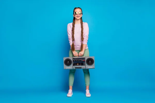 Full length foto di positivo allegro ragazzo con trecce ragazza tenere cassetta record boombox vuole partito retrò a riposo rilassarsi indossando rosa maglione scarpe da ginnastica isolato su sfondo di colore blu — Foto Stock