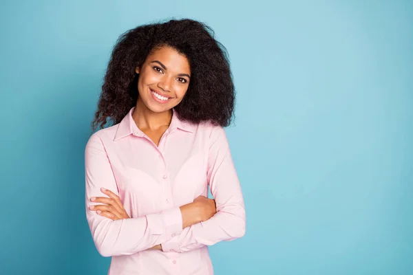 Foto di stupefacente ondulato scuro pelle affari signora incrocio braccia autoreferenziale look usura rosa formalwear camicia isolato blu colore sfondo — Foto Stock