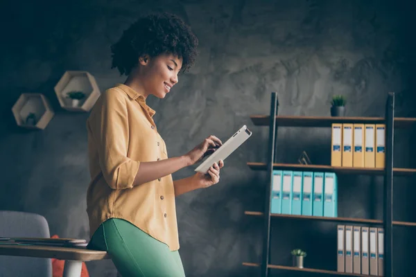 Foto del lado del perfil del agente de bienes raíces afro americano fresco inteligente tableta de trabajo leer noticias de inicio charlando con colegas de la empresa en la oficina loft — Foto de Stock