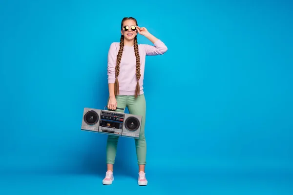 Celotělová fotka moderního mládí s copánky copánky dívka držet retro boombox cítit šílený chtít party na jarní prázdniny nosit růžový svetr tenisky zelené kalhoty kalhoty izolované modré pozadí — Stock fotografie