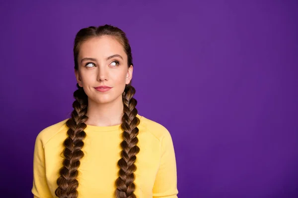Photo of tricky mood lady long braids hairdo looking cunning empty space have crazy idea wear casual yellow pullover isolated purple color background — Stockfoto